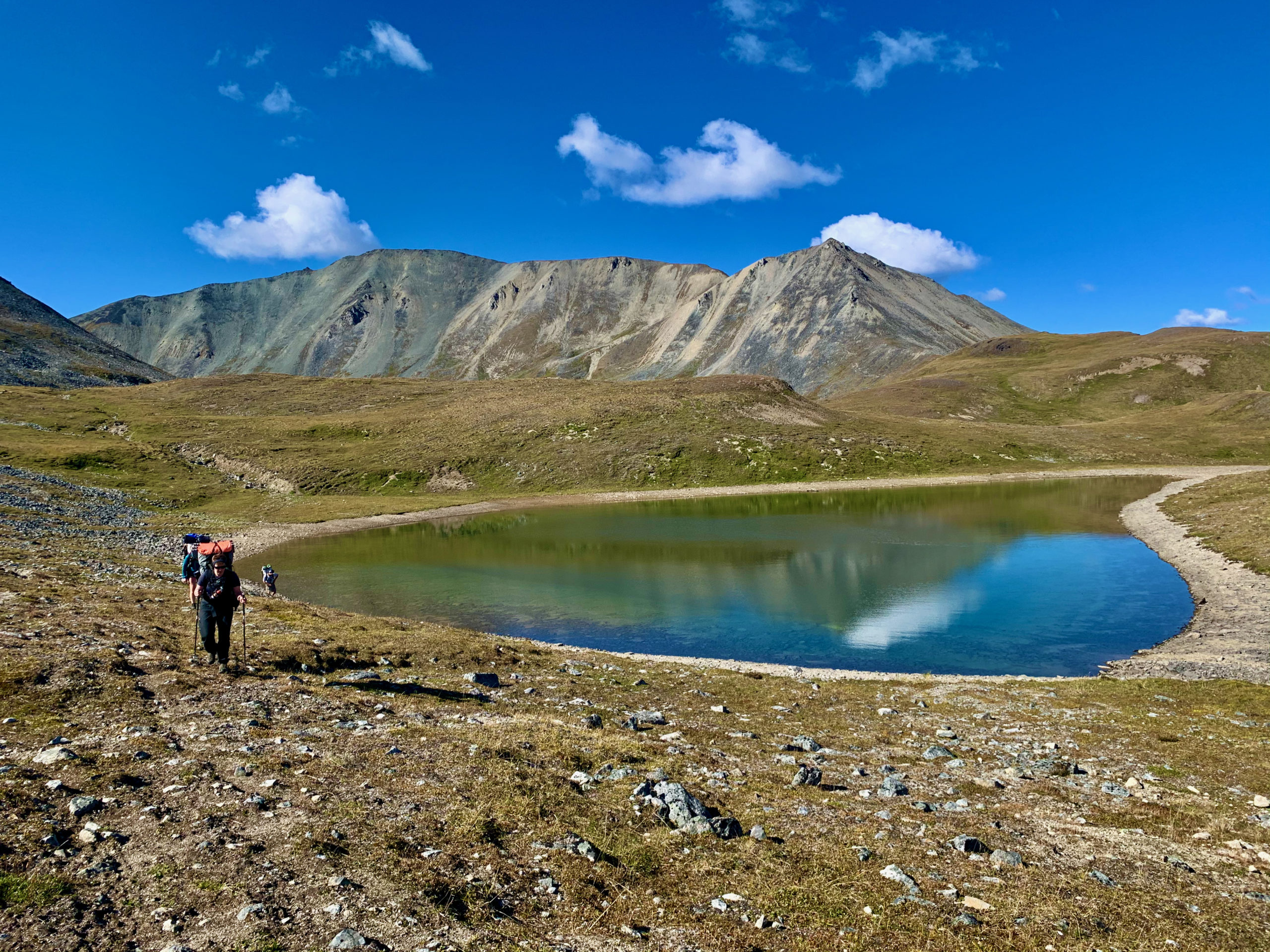 Backpackers near an alpine lake in the Talkeetna Mountains